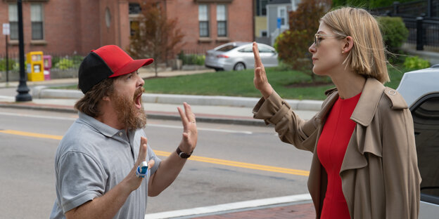 Auf einer Straße stehen sich ein Mann und eine Frau mit wütenden Gesten und Gesichtern gegenüber