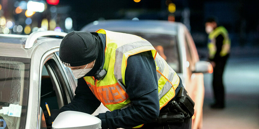 Ein Bundespolizist beugt sich zu einem Autofenster hinunter