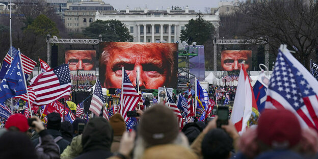 Trump Unterstützer vor großen Video-Screens die Donalt Trump zeigen