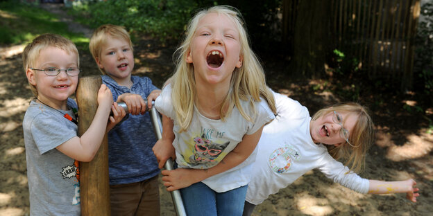 Eine Gruppe von Kindern mit Zahnlücken lacht in die Kamera