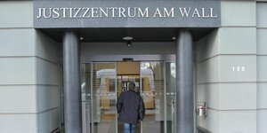 Eine Person betritt das Justizzentrum am Wall in Bremen, in dem auch das Bremer Arbeitsgericht untergebracht ist