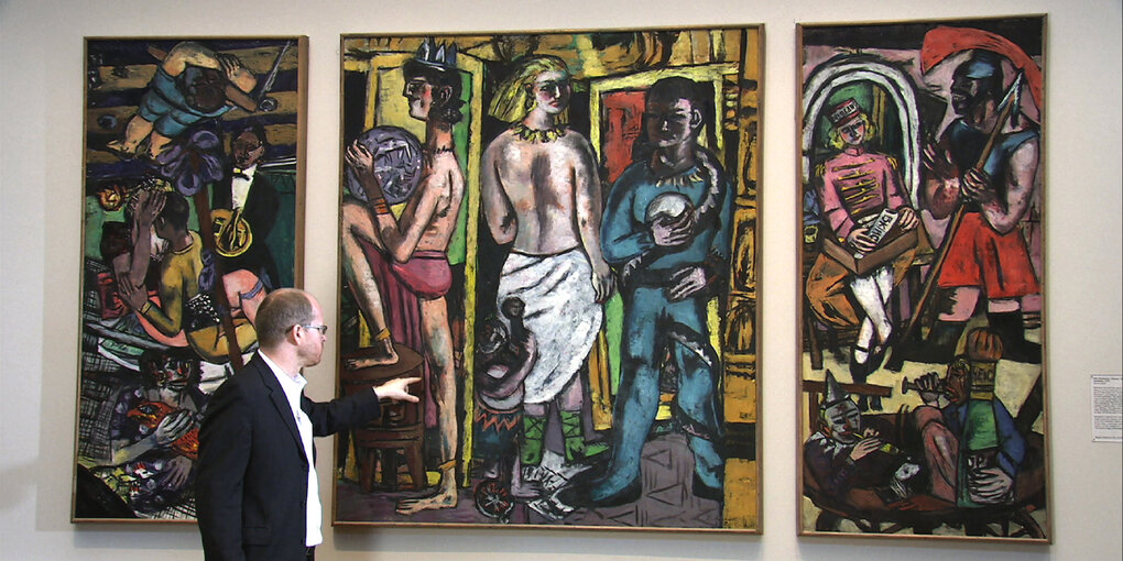 Szene aus der Dokumentation "Max Beckmann - Departure": Ein Ausstellungsguide erläurtert Beckmanns Triptychon "Akrobaten"