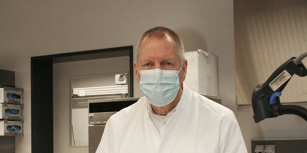 Der Pathologe Christoph Röcken steht hinter einem Arbeitstisch.