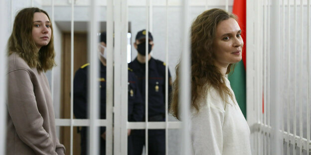 Die Journalistinnen Katerina Bachwalowa (r.) und Daria Tschulzowa (l.) in einem Käfig von Wachmännern beaufsichtigt bei der Verhandlung