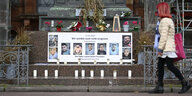 Gedenktafeln mit Bildern der Opfer des Anschlags und Kerzen am Brüder-Grimm-Denkmal auf dem Marktplatz von Hanau