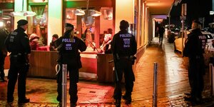 Polizisten stehen vor einer Berliner Shisha-Bar, in der eine Razzia stattfindet
