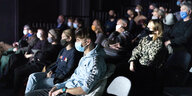 Theaterzuschauer tragen Mund-Nasen-Schutz