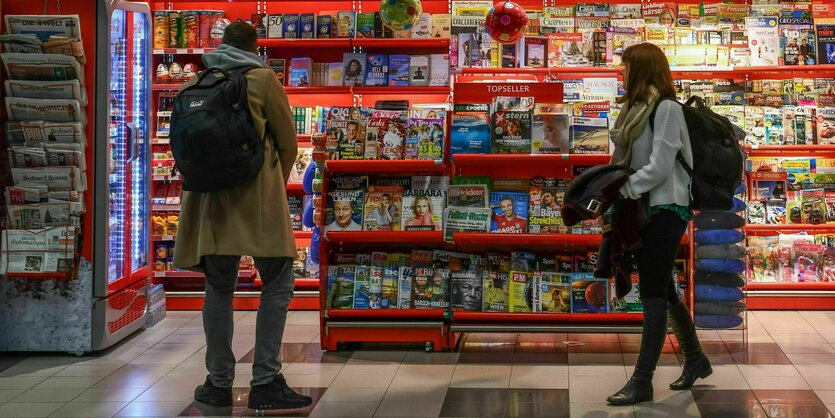 Zwei Personen an einem Zeitungskiosk am Flughafen