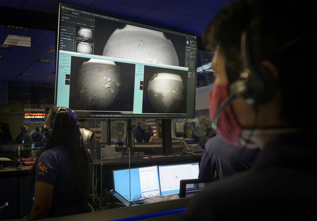 Zwei Nasa Mitarbeiter schauen auf Monitoren Zwei Nasa Mitarbeiter schauen auf Monitoren