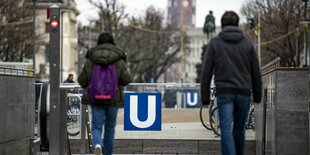 Menschen gehen zum Eingang des U-Bahnhofs Unter den Linden in Berlin