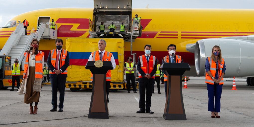 Vor einem Flugzeug stehen Ivan Duque und weitere Menschen bei einer Rede