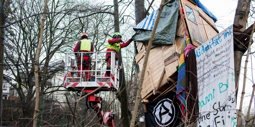 Arbeiter auf Hebebühne nähern sich einem Baumhaus