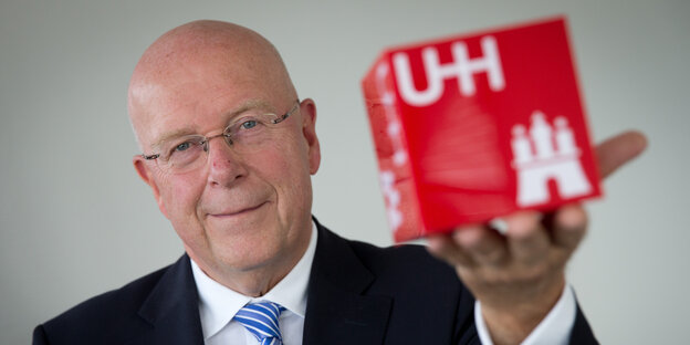 Dieter Lenzen hält einen Würfel mit UHH-Logo in der Hand