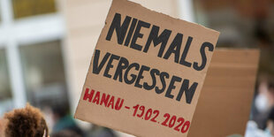 Ein Pappschild auf dem steht: "Niemals vergessen"