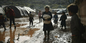 Kinder spielen im Schlamm in einem geflüchteten-Campus in Idlib