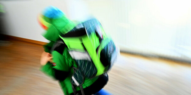 Ein Kind rennt nach dem Unterricht über den Flur seiner Grundschule