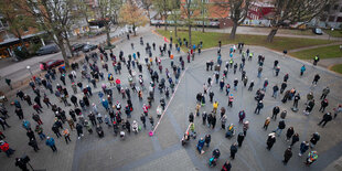 Menschen stehen mit Abstand auf dem Joseph-Carlebach-Platz