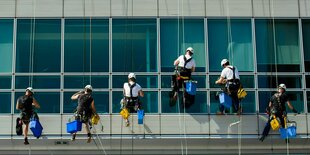 Reinigungskräfte an einer Häuserfassade