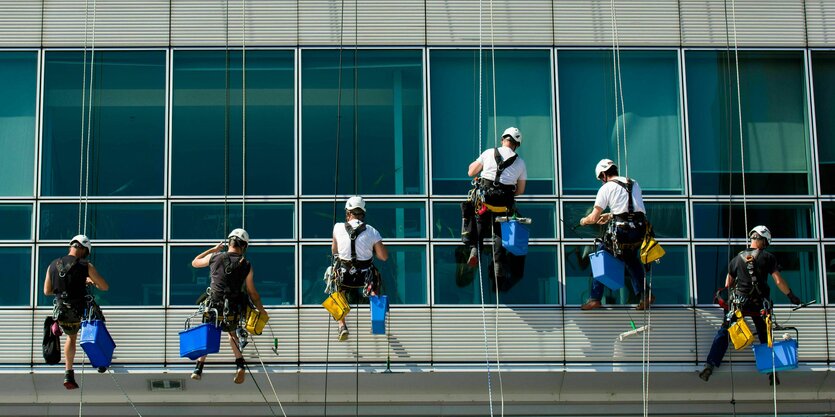 Reinigungskräfte an einer Häuserfassade