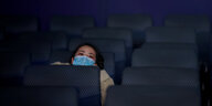 eine Frau sitzt in einer Kinoreihe