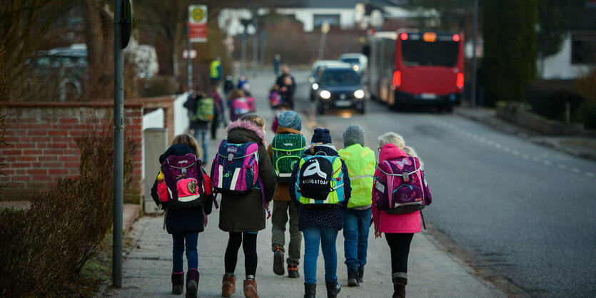 Kinder mit Schulranzen auf einem Gehweg