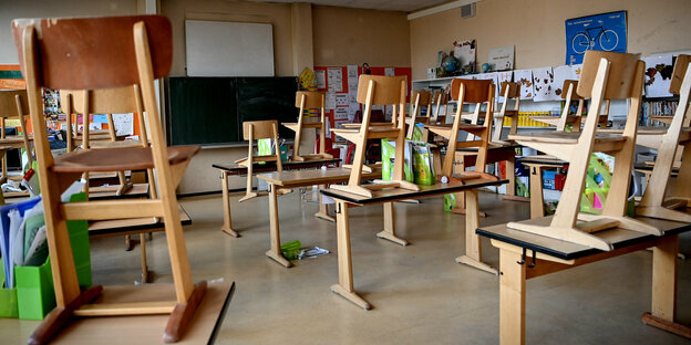 Stühle in einem Klassenzimmer stehen auf den Tischen