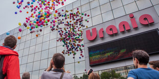 Luftballons steigen vor einem Haus in die Höhe