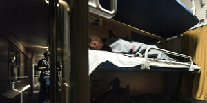 Ein Mann liegt im Schlagwagenabteil und schläft