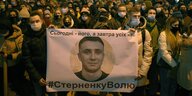 Demonstranten in Lviv halten ein Plakat auf dem ein ein Abbild von Serhii Sternenko abgebildet ist