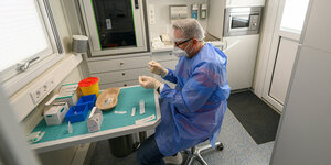 Ein Mitarbeiter in Schutzkleidung bereitet Impfstoff vor