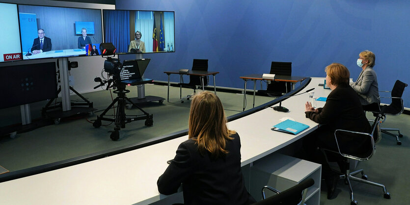 Bundeskanzlerin Merkel sitzt mit anderen Personen in einer Videoschalte.