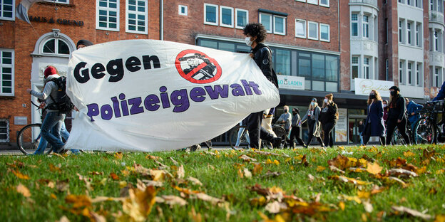 Teilnehmer gehen mit einem Transparent, "Gegen Polizeigewalt", auf einer Demonstration gegen die Novellierung des Polizeirechts in Schleswig-Holstein durch die Innenstadt.