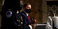 Der frühere Kapitol-Polizeichef sitzt mit Maske in der Anhörung