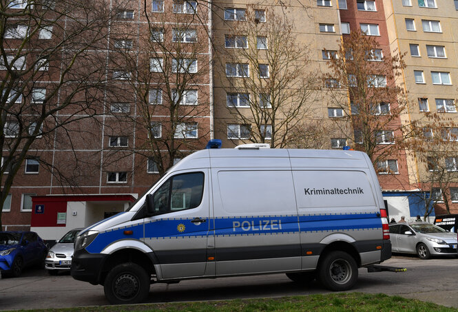 Ein Polizeiauto steht vor einem Hochhaus