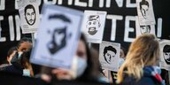 Bei einer Demo zum Gedenken an Hanau halten Teilnehmer Plakate mit Bildern der Opfer des Anschlags