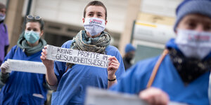 Pflegekräfte protestieren mit Transparenten auf der Straße