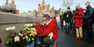 Menschen mit Blumen. Im Hintergrund der Kreml