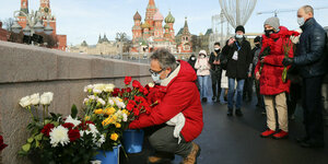Menschen mit Blumen. Im Hintergrund der Kreml