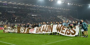 St. Pauli-Mannschaft mit Fanbanner