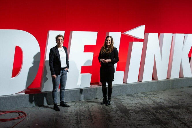 Die neuen Linken-Chefinnen stehen vor rot-weißem Hintergrund.