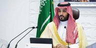 Mohammed bin Salman hinter einem Mikrofon vor der saudischen Flagge