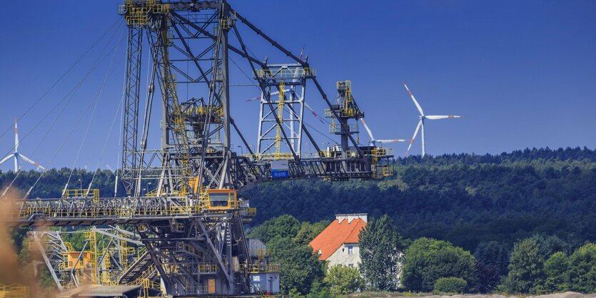 Ein Braunkohlebagger im Braunkohletagebau Welzow in der Lausitz. Im Hintergrund sind Windräder zu sehen