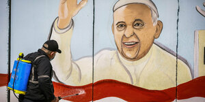 Eine Wandbemalung zeigt Papst Franziskus über der irakischen Flagge