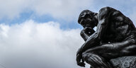 Die Plastik Der Denker von Auguste Rodin vor wolkigem Himmel