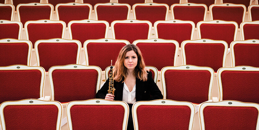 Frau mit Oboe im leerenZuschauersall der Staatsoper Berlin