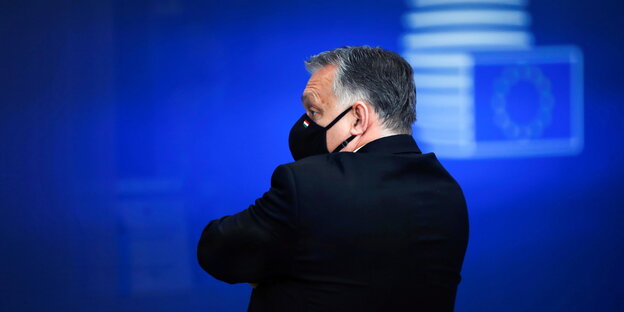 Der ungarische Ministerpräsident und Fidesz-Vorsitzende Viktor Orbán vor einer blauen Wand mit Europaflagge dreht den Rücken zu