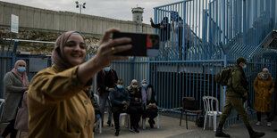 Palästinenserin macht ein Selfie nach Impfung direkt am Grenzkontrollpunkt zwischen Israel und dem Westjordanland