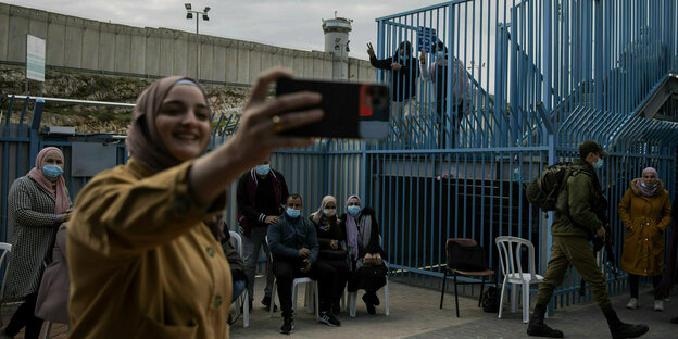 Palästinenserin macht ein Selfie nach Impfung direkt am Grenzkontrollpunkt zwischen Israel und dem Westjordanland