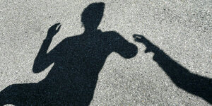 Schattenbild: Mann greift nach Frau. Die wendet sich ab