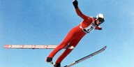 Ein Skispringer in der Luft, er verliert den rechten Ski.